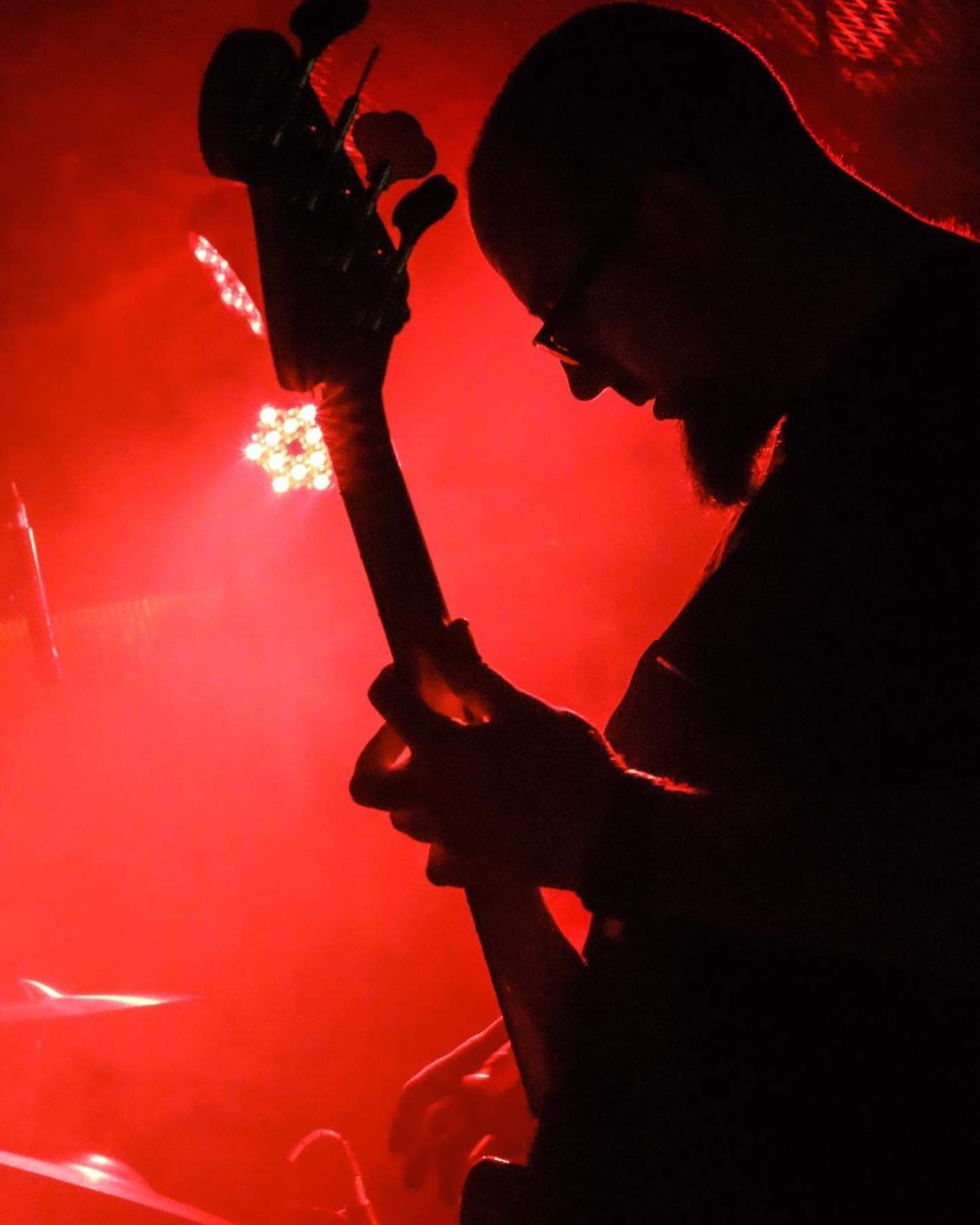 A red-tinted silhouette of Christopher live on stage