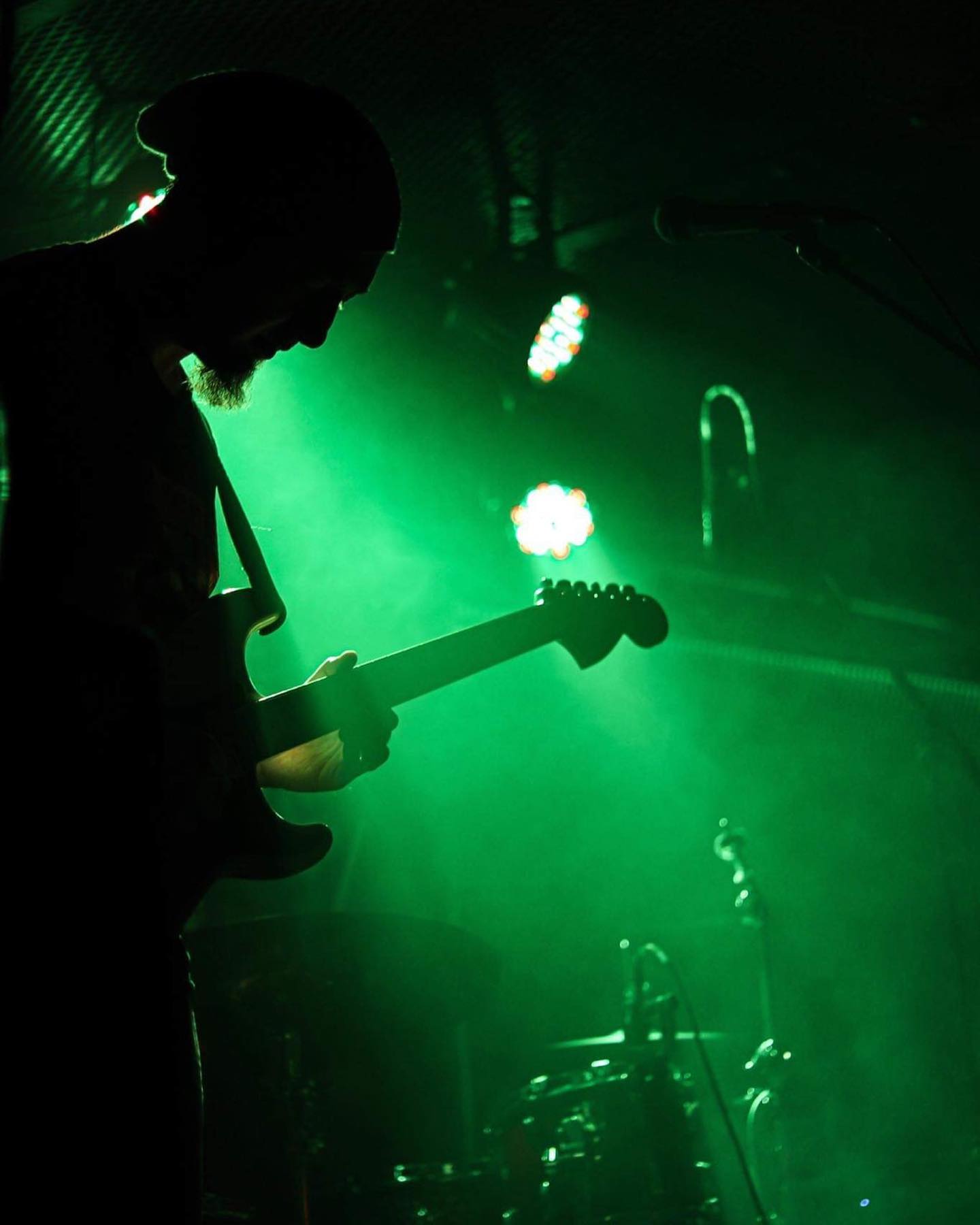 A green-tinted silhouette of Moe live on stage
